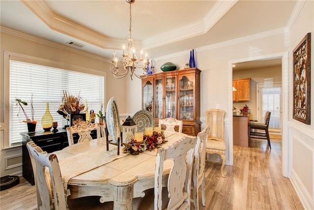 3258 Kessock Ridge Trl, Snellville, GA 30039 - dining space with a chandelier, a raised ceiling, light wood-style flooring, and crown molding