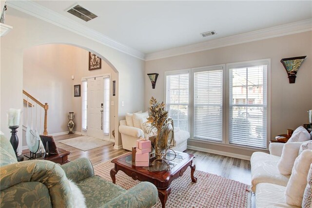 3258 Kessock Ridge Trl, Snellville, GA 30039 - living room featuring arched walkways, crown molding, wood finished floors, and stairs