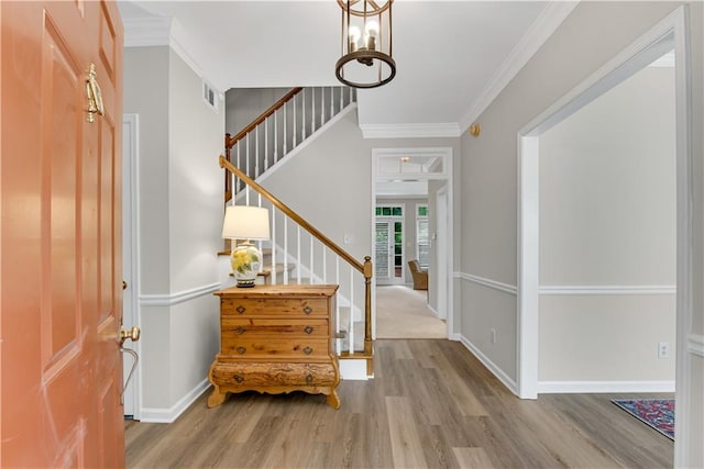 entrance foyer featuring ornamental molding and wood-type flooring