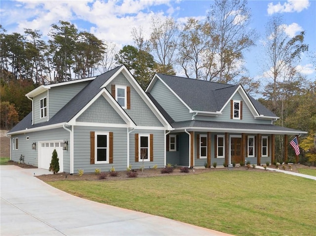 view of front facade with covered porch, a front yard, and a garage