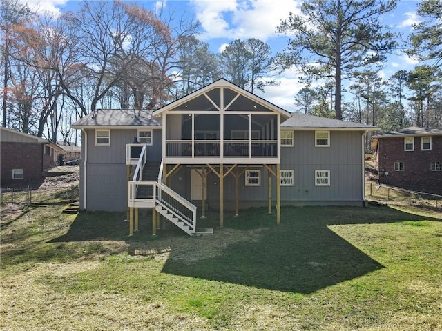 rear view of property with stairway, fence, a yard, and a sunroom