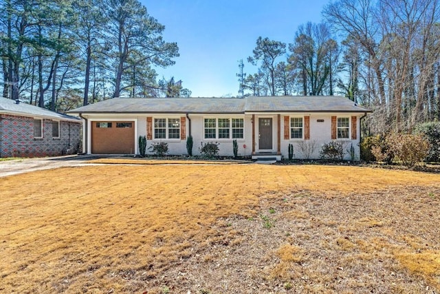 single story home featuring driveway, brick siding, an attached garage, and a front lawn