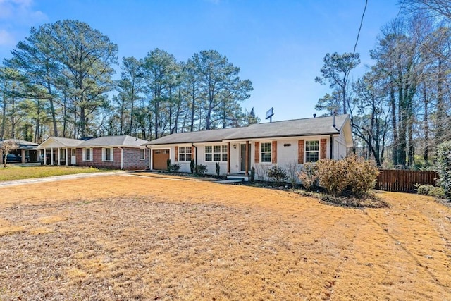 ranch-style house with an attached garage, fence, and brick siding