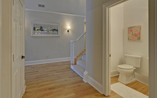 staircase featuring ornamental molding and hardwood / wood-style flooring