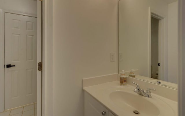 bathroom with toilet, vanity, and tile patterned floors