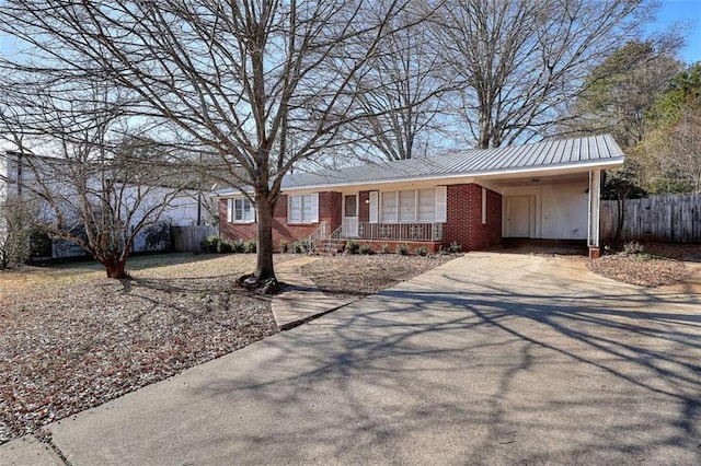 707 E Spring St E, Monroe, GA 30655 - ranch-style home featuring fence, driveway, brick siding, an attached carport, and a porch