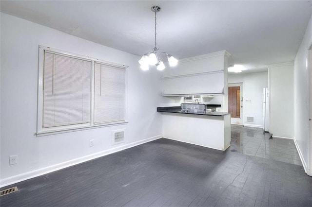 707 E Spring St E, Monroe, GA 30655 - kitchen featuring a peninsula, a chandelier, baseboards, dark countertops, and dark wood finished floors