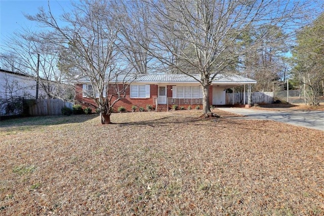 707 E Spring St E, Monroe, GA 30655 - ranch-style house with fence, concrete driveway, an attached carport, and brick siding