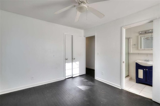 707 E Spring St E, Monroe, GA 30655 - unfurnished bedroom with a sink, ensuite bath, baseboards, and a ceiling fan