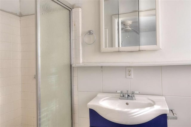 707 E Spring St E, Monroe, GA 30655 - bathroom featuring tile walls, a shower stall, vanity, ceiling fan, and decorative backsplash