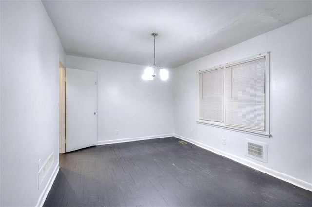 707 E Spring St E, Monroe, GA 30655 - empty room featuring dark wood-type flooring, baseboards, and a chandelier