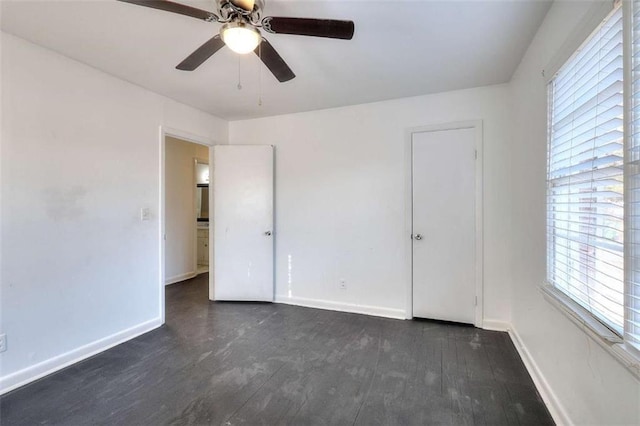707 E Spring St E, Monroe, GA 30655 - unfurnished bedroom featuring dark wood-type flooring, baseboards, and ceiling fan