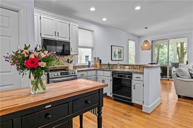 137 Oakton S, Eatonton, GA 31024 - kitchen with butcher block countertops, a sink, black appliances, a peninsula, and white cabinetry
