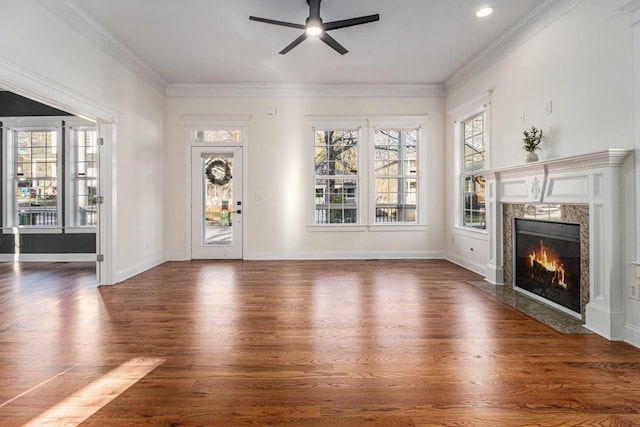 unfurnished living room featuring crown molding, a premium fireplace, baseboards, ceiling fan, and dark wood-style flooring