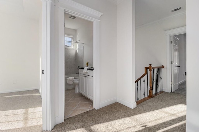 corridor with visible vents, ornamental molding, light carpet, an upstairs landing, and light tile patterned flooring