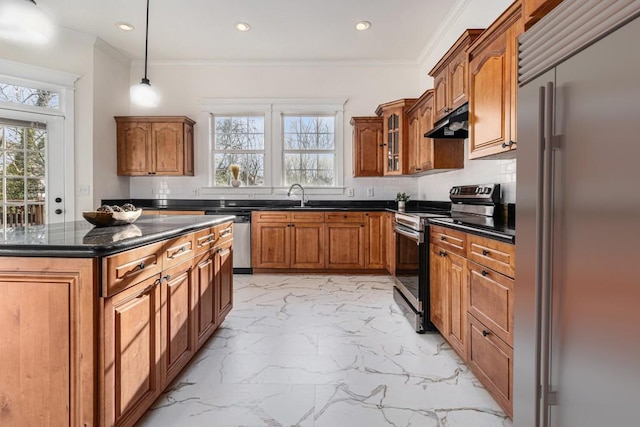 kitchen featuring brown cabinetry, plenty of natural light, under cabinet range hood, appliances with stainless steel finishes, and marble finish floor