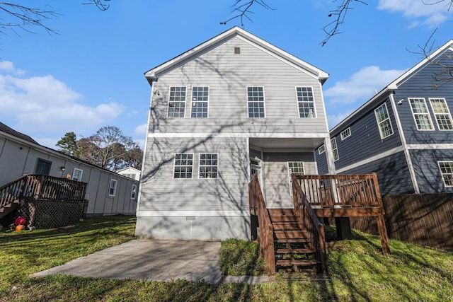 back of property with fence, a wooden deck, a yard, stairs, and crawl space