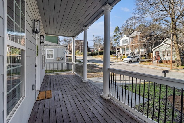 wooden deck featuring covered porch and a residential view