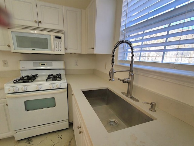 kitchen featuring white cabinetry, white appliances, and sink