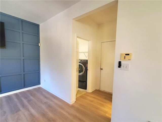 laundry room with washer / clothes dryer and light hardwood / wood-style flooring