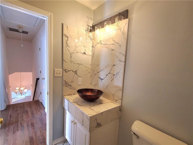 bathroom with hardwood / wood-style floors, vanity, and toilet