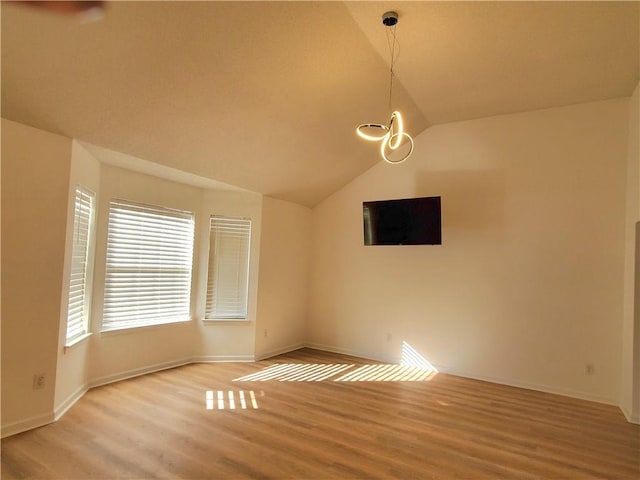 interior space featuring light hardwood / wood-style floors, vaulted ceiling, and a notable chandelier