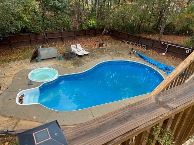 view of pool with an in ground hot tub and a patio