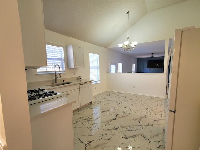 kitchen featuring white appliances, sink, vaulted ceiling, a notable chandelier, and white cabinetry