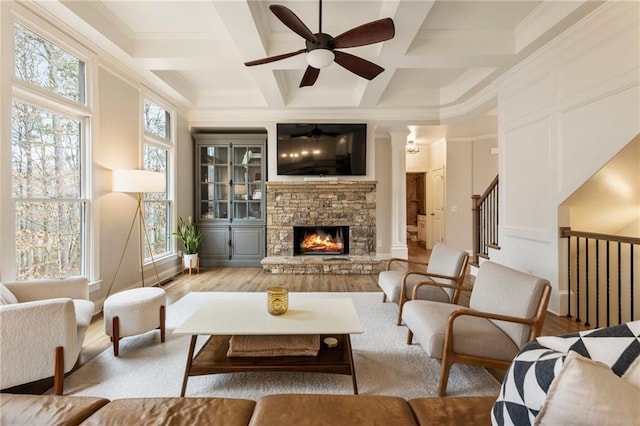 sitting room with beam ceiling, coffered ceiling, wood finished floors, and a fireplace