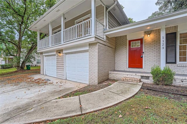 doorway to property with a balcony and a garage