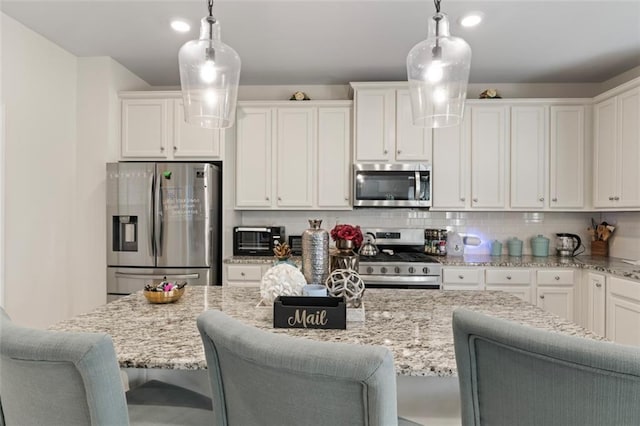 297 Aylesbury Blvd, Mcdonough, GA 30252 - kitchen featuring appliances with stainless steel finishes, white cabinetry, tasteful backsplash, and a breakfast bar area