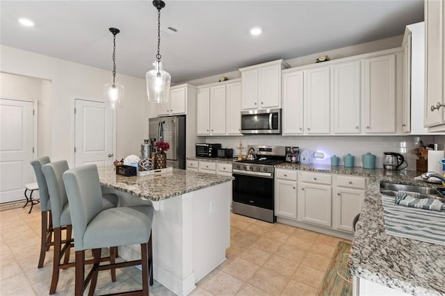 297 Aylesbury Blvd, Mcdonough, GA 30252 - kitchen with stainless steel appliances, a center island, decorative backsplash, white cabinets, and recessed lighting