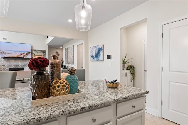 297 Aylesbury Blvd, Mcdonough, GA 30252 - kitchen featuring open floor plan, white cabinets, light stone countertops, decorative light fixtures, and light tile patterned floors