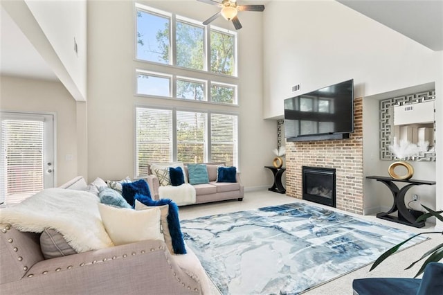 297 Aylesbury Blvd, Mcdonough, GA 30252 - living area with a towering ceiling, carpet flooring, a ceiling fan, and a brick fireplace