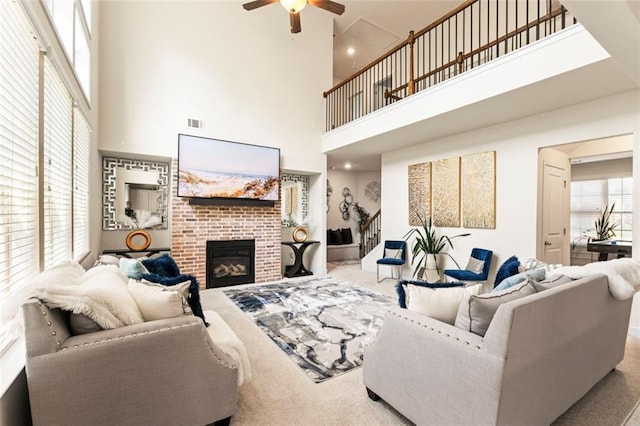 297 Aylesbury Blvd, Mcdonough, GA 30252 - living area featuring carpet flooring, a high ceiling, ceiling fan, a brick fireplace, and stairs