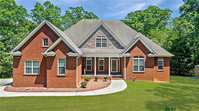 craftsman-style house featuring a front yard, a porch, and brick siding
