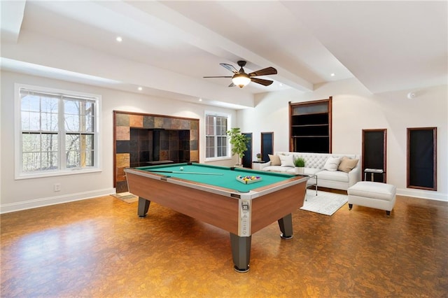 rec room featuring ceiling fan, pool table, beam ceiling, and a tiled fireplace