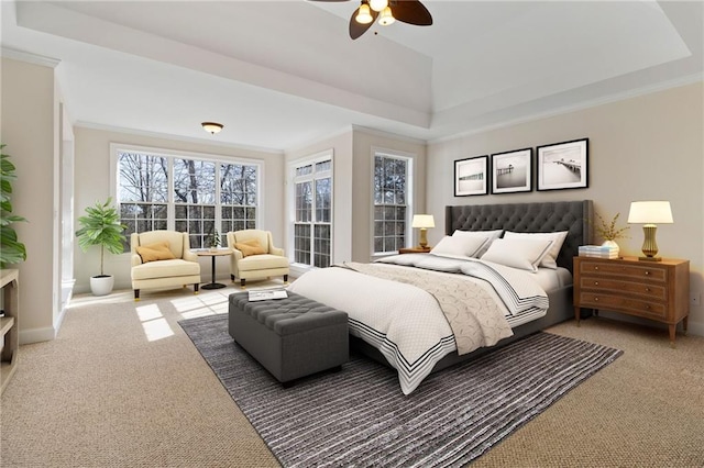 bedroom featuring a raised ceiling, ceiling fan, baseboards, and carpet