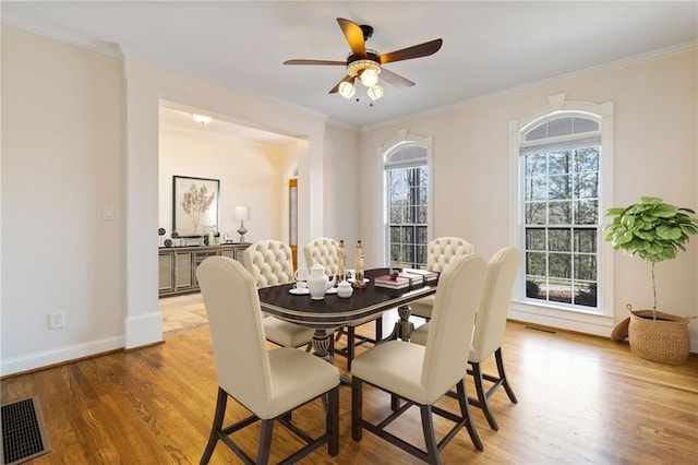 dining room with hardwood / wood-style flooring, ceiling fan, and ornamental molding