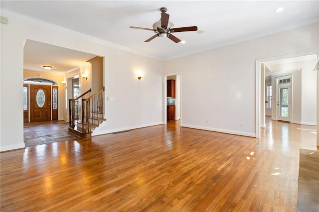 unfurnished living room featuring stairway, baseboards, a ceiling fan, and wood finished floors