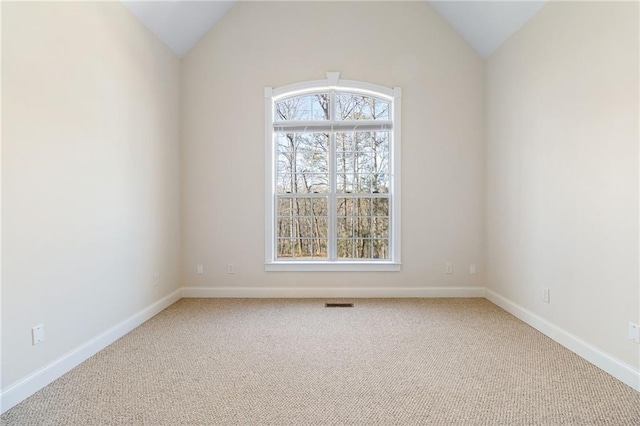 spare room featuring vaulted ceiling and carpet