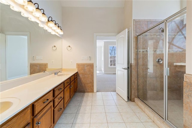 bathroom featuring a shower stall, tile patterned floors, double vanity, and a sink