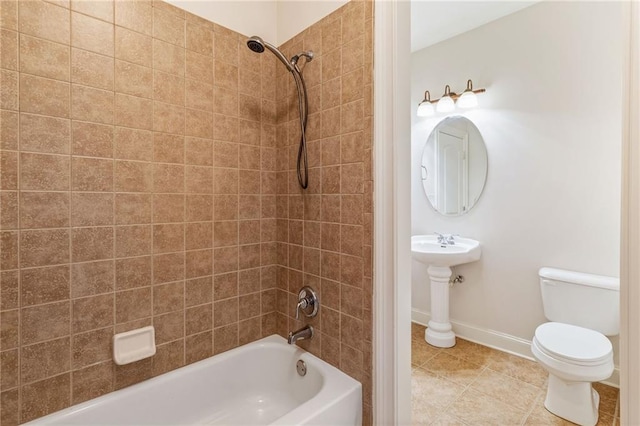 full bathroom with sink, tiled shower / bath combo, and toilet