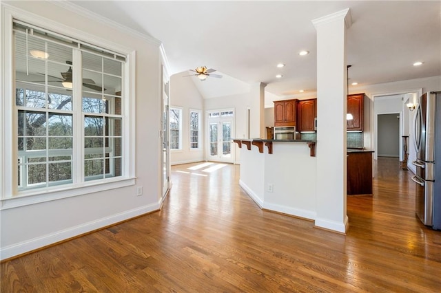 kitchen featuring ornamental molding, ceiling fan, a breakfast bar area, and stainless steel appliances