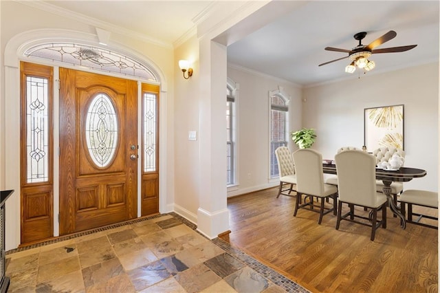 entryway with stone finish flooring, baseboards, a ceiling fan, and crown molding