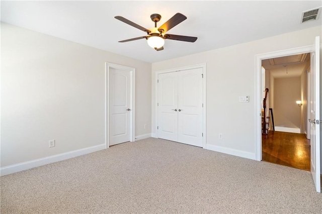 unfurnished bedroom with ceiling fan, carpet floors, and a closet