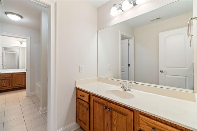 full bath featuring vanity, tile patterned flooring, visible vents, baseboards, and a bathtub