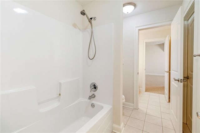 bathroom with tile patterned floors, shower / bathtub combination, baseboards, and toilet
