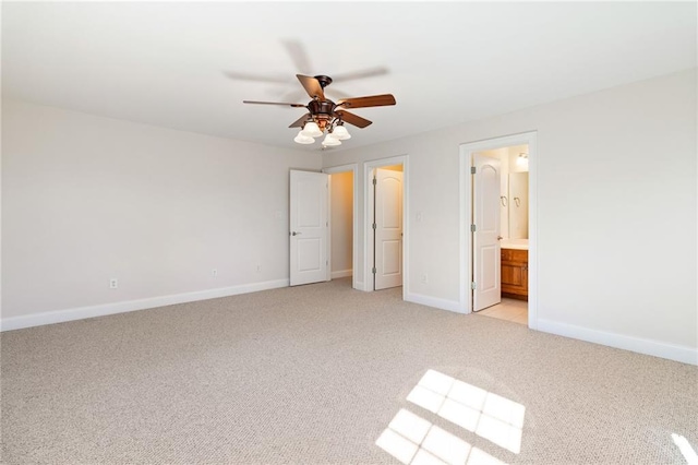 unfurnished bedroom with ceiling fan, ensuite bath, and light carpet