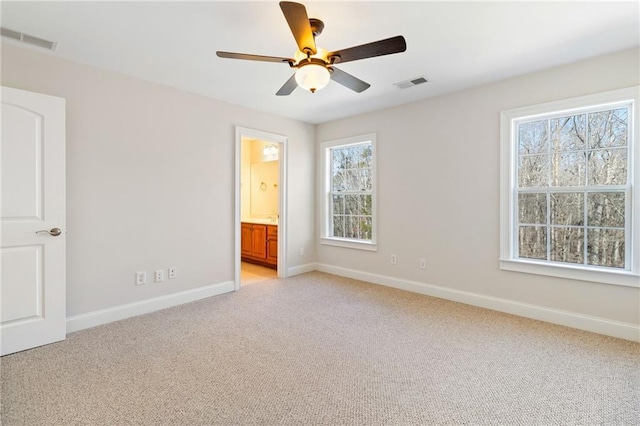 unfurnished bedroom featuring visible vents, baseboards, multiple windows, and light carpet